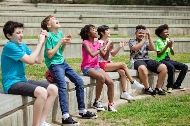 Kids sitting outside in an amphitheater