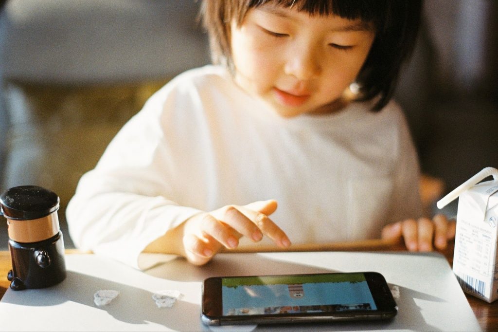Little girl playing on a mobile phone