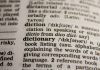 Shallow depth-of-field close-up of the word “dictionary” in a dictionary