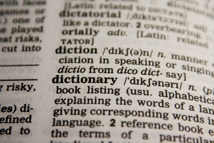 Shallow depth-of-field close-up of the word “dictionary” in a dictionary