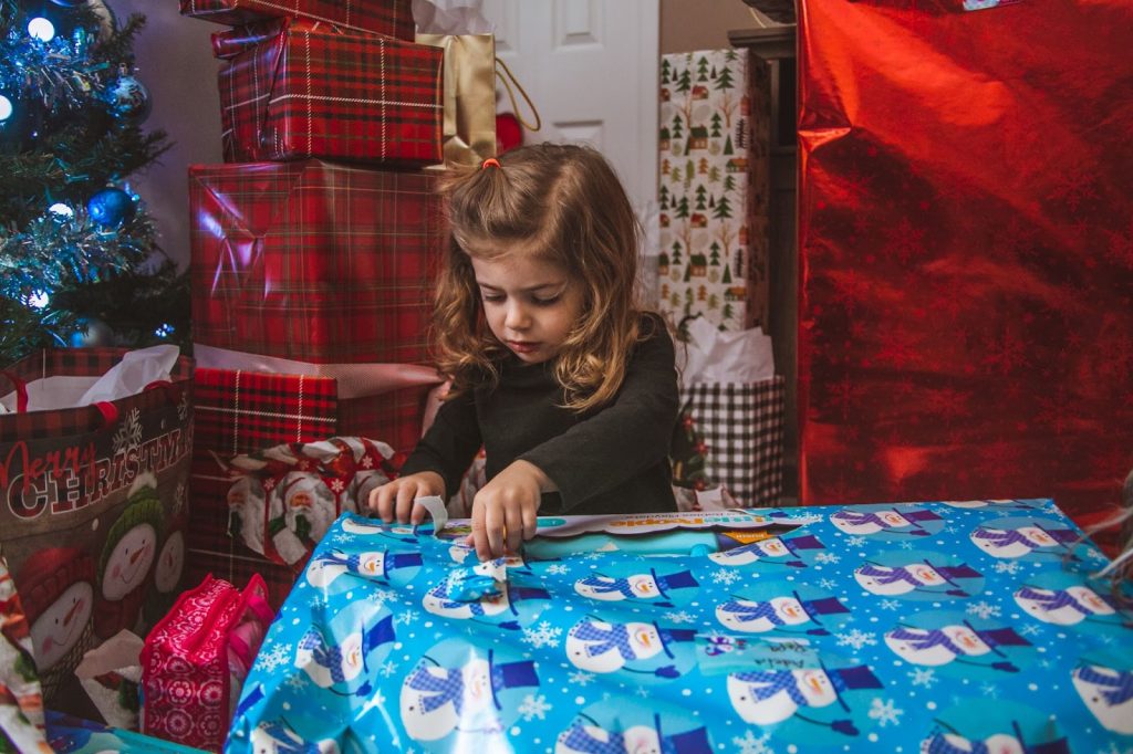 Girl unwrapping her Christmas gift