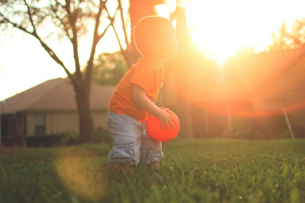 Kid playing with a ball in a park