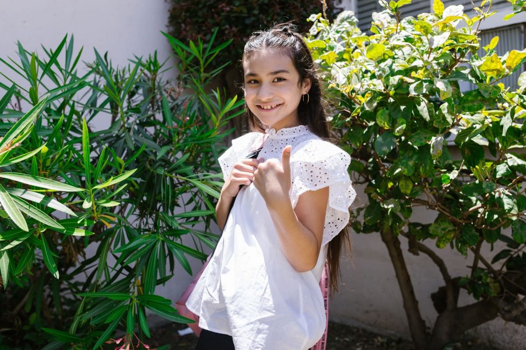 Girl in white dress near green plants