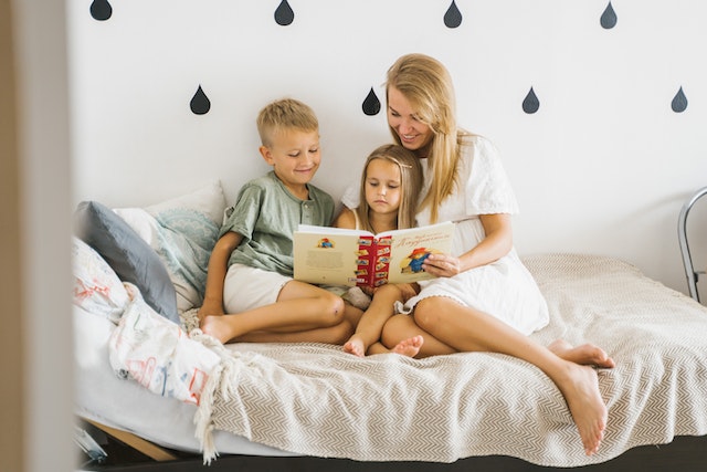 Mother and children reading book