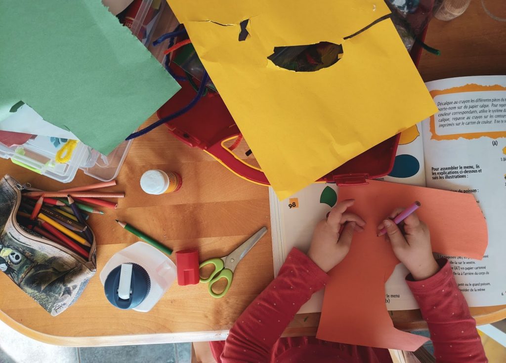 Kid coloring on colored paper