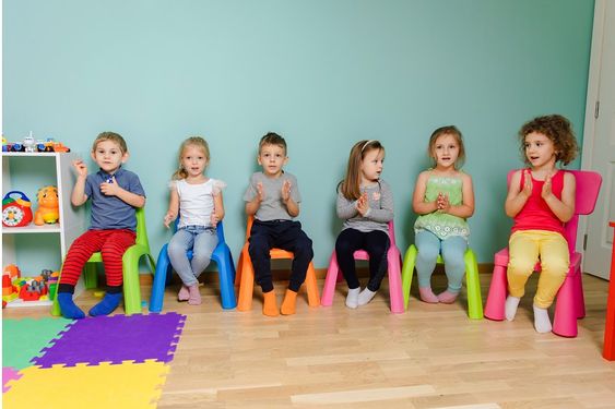 Kids sitting on colorful chairs playing a game