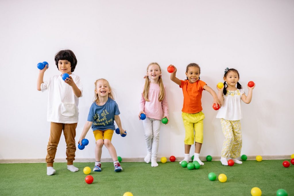 Little boys and girls playing with colorful balls