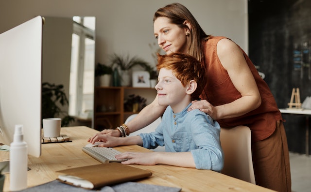 Parent helping child finish homeschool assignment