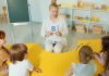 A Woman in White Long Sleeves Sitting in Front of Kids