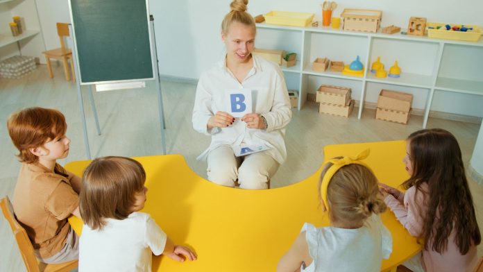 A Woman in White Long Sleeves Sitting in Front of Kids