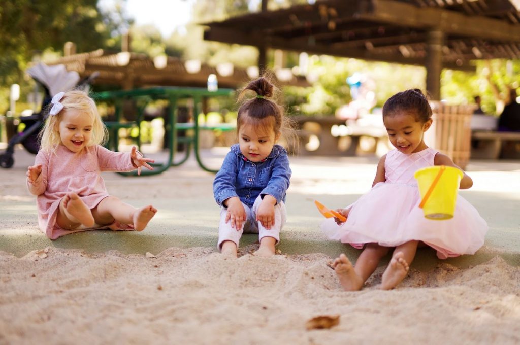 Little girls playing with sand