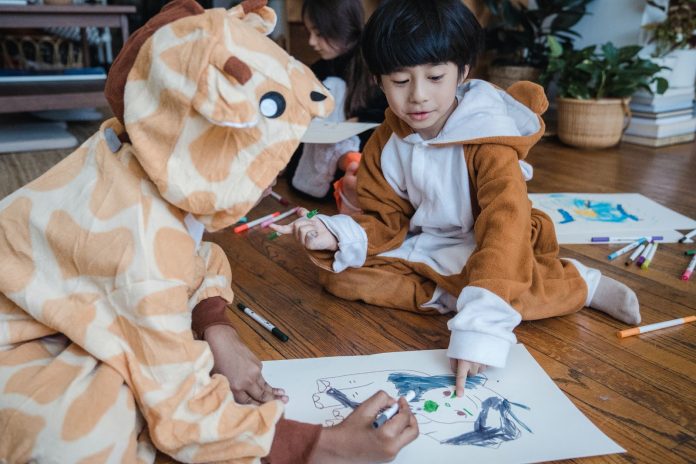 Kids wearing costumes and making art indoors