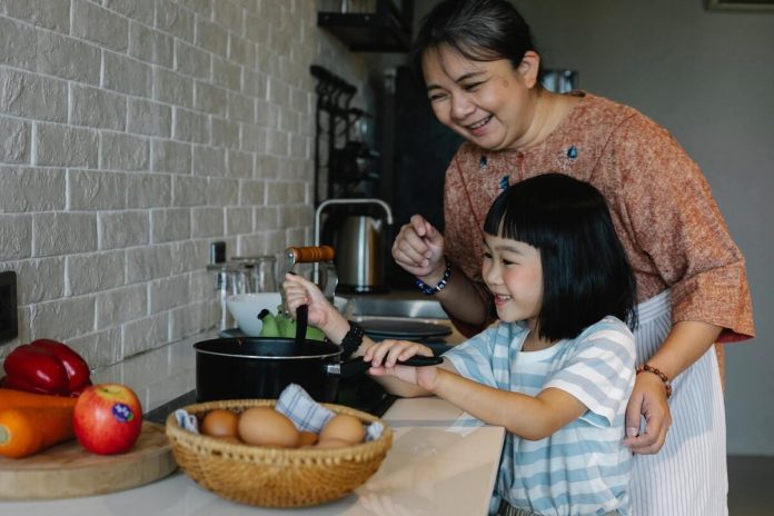 A woman cooking with a little girl