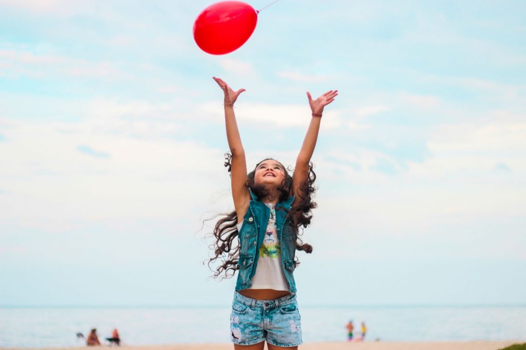 Child playing with a balloon and feeling happy