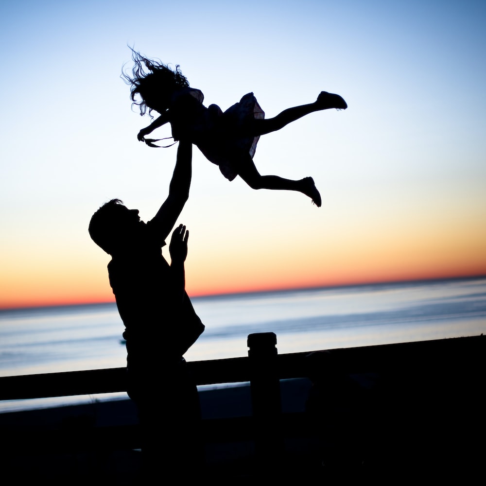 Son and dad playing near an ocean