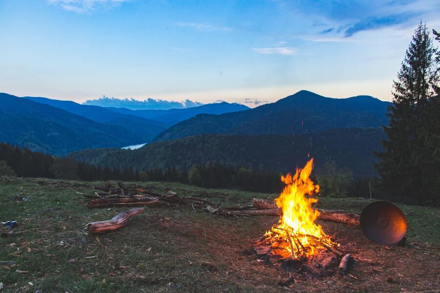 A camp fire outdoors in a grass field