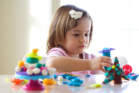 Little girl making craft with clay