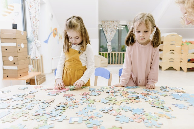 Two little girls playing with puzzles