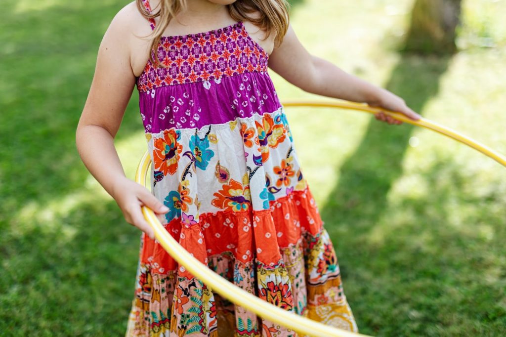 A young girl plays with a hula hoop
