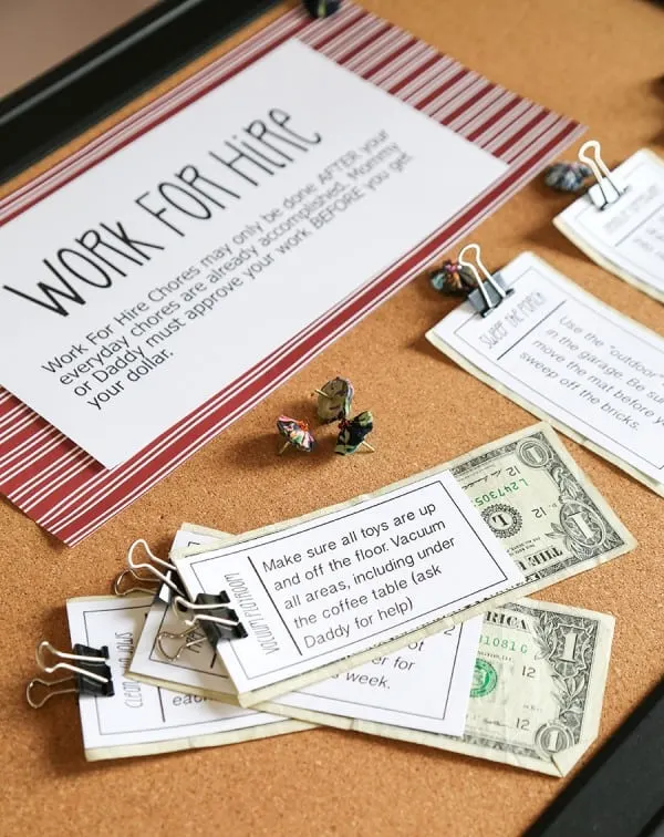 A work for hire board with chores slipped onto single dollar notes