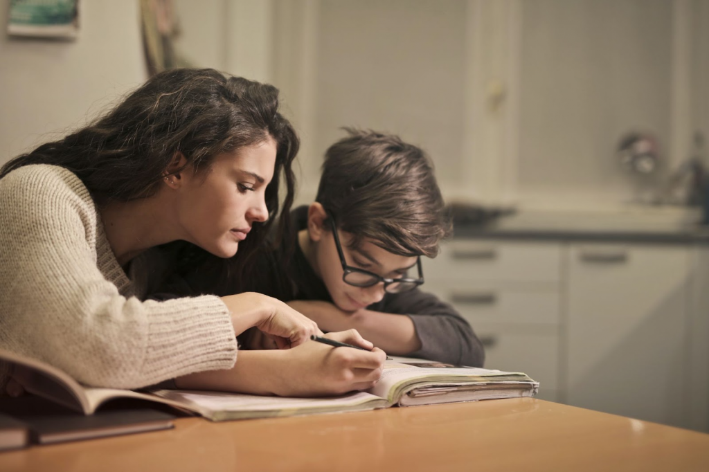 Mother helping kid with writing