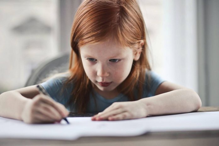 Little girl writing on paper