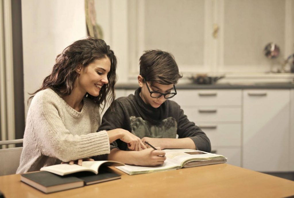 Mother helping her kid in writing