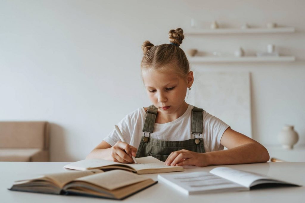 Little girl writing in her notebook