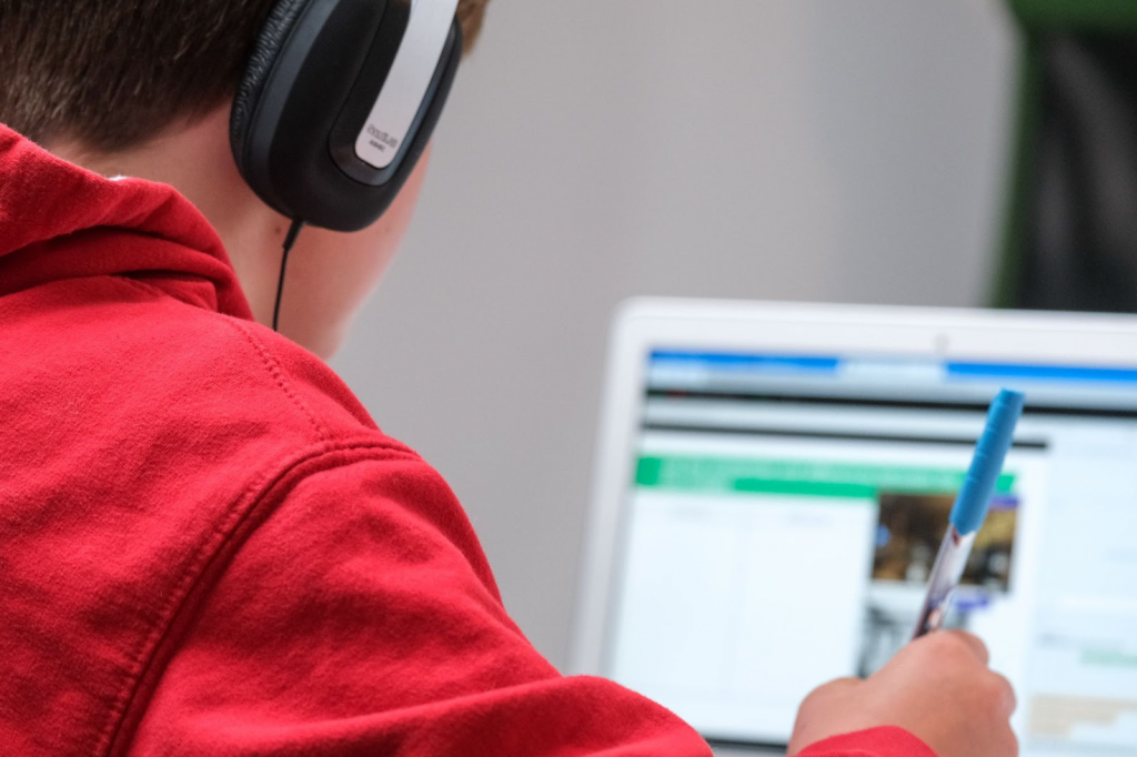 Boy studying on a laptop with his headphones on