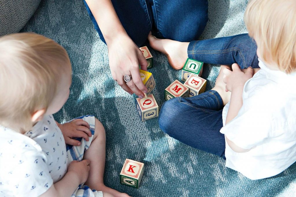 Two toddlers playing with building blocks