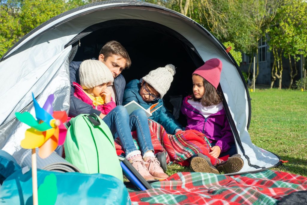 Kids with their dad inside a tent