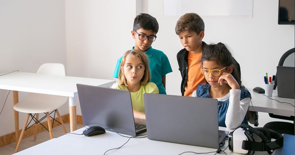 Children using laptops together