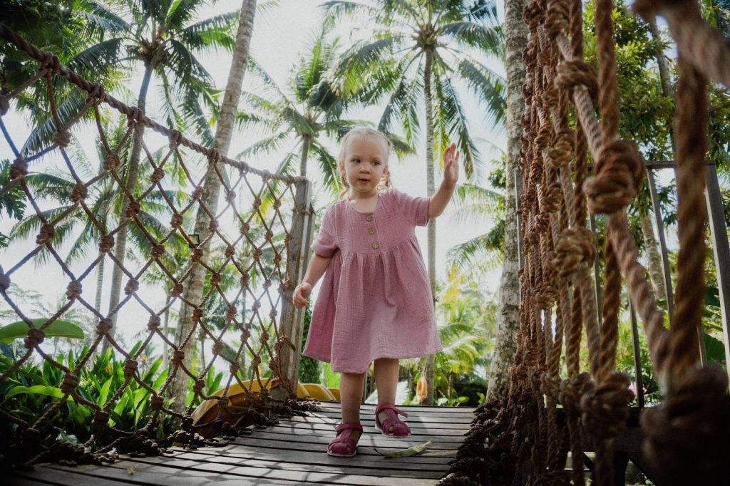 Little Girl Walking Across a Rope Bridge