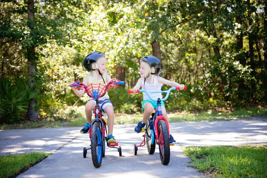 Two little girls riding bikes together