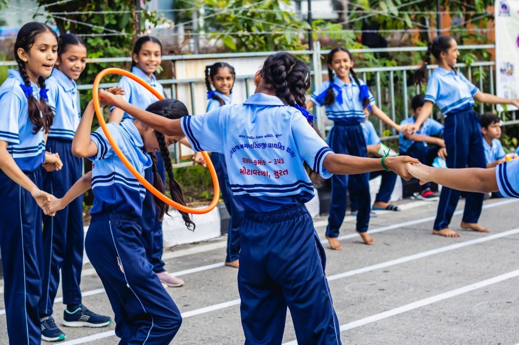 School girls playing with a hula hoop
