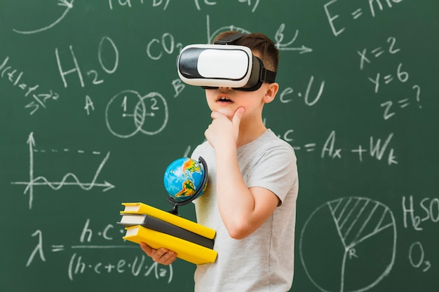 Little boy using a VR while carrying books