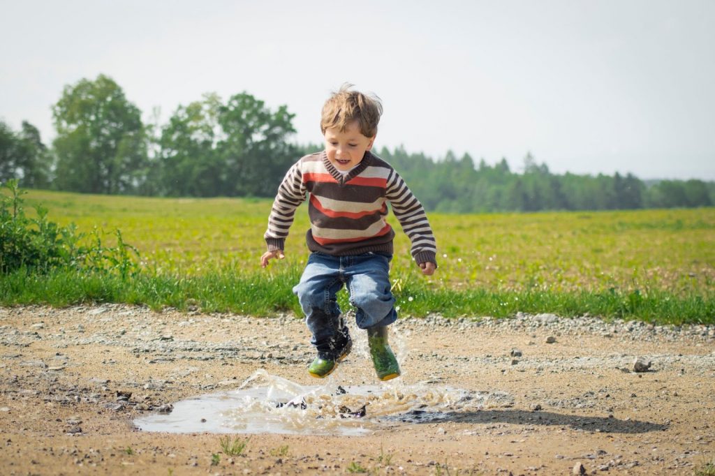 Boy Jumping in mud at Daytime