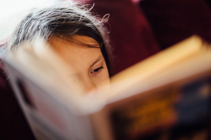 A girl reading a book with focus