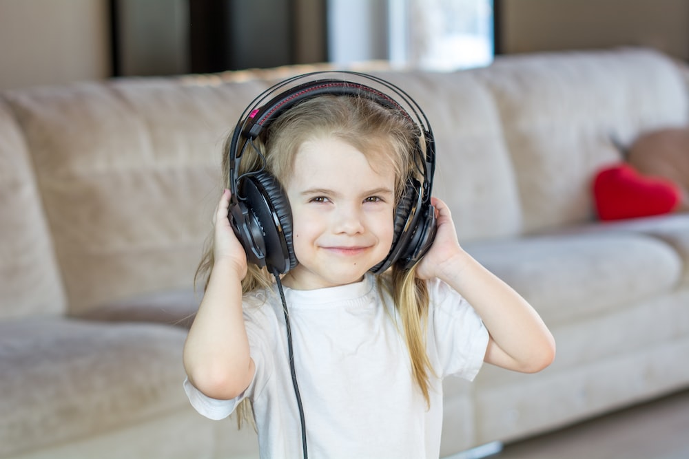Little girl listening to a song with headsets on