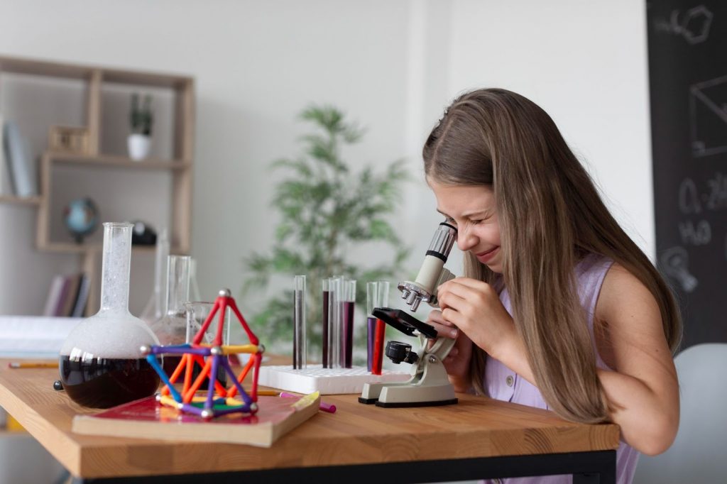 A girl looking through microscope