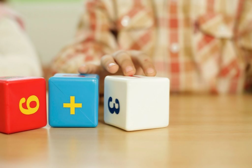 Hand of a Child Playing With Educational Toy Blocks