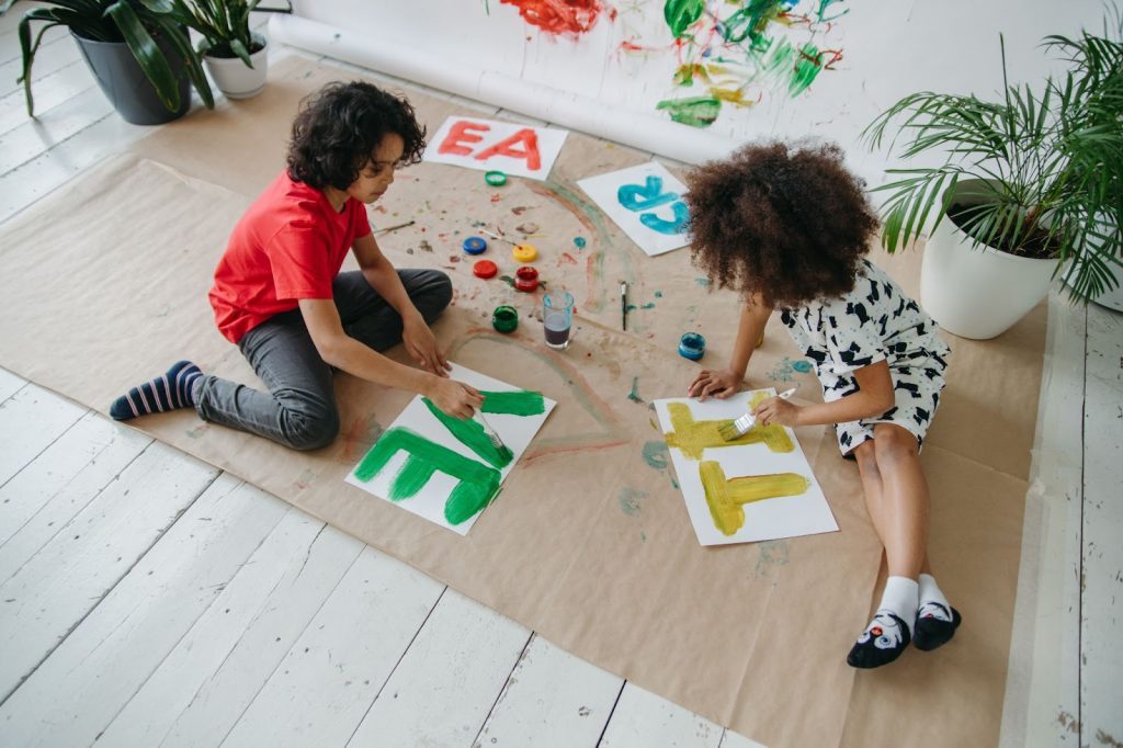 A boy and girl painting on the floor