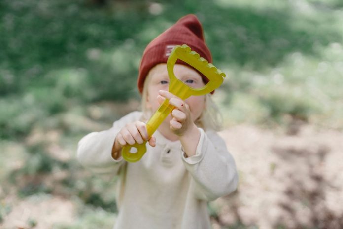 Little boy playing with a toy rake