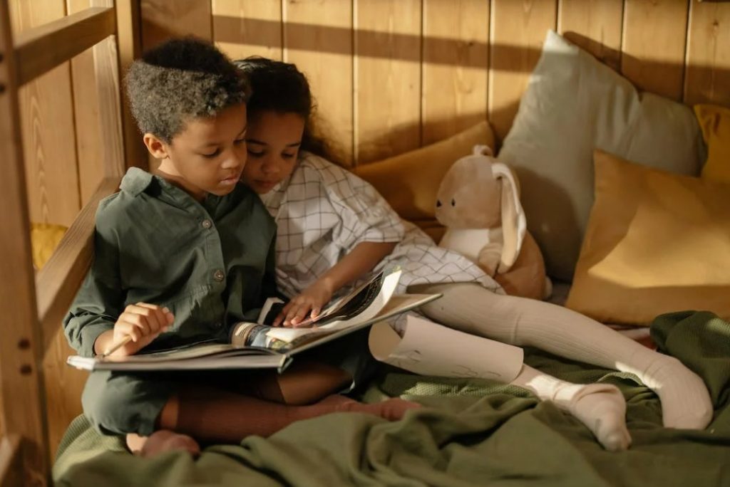 Two kids reading a book together