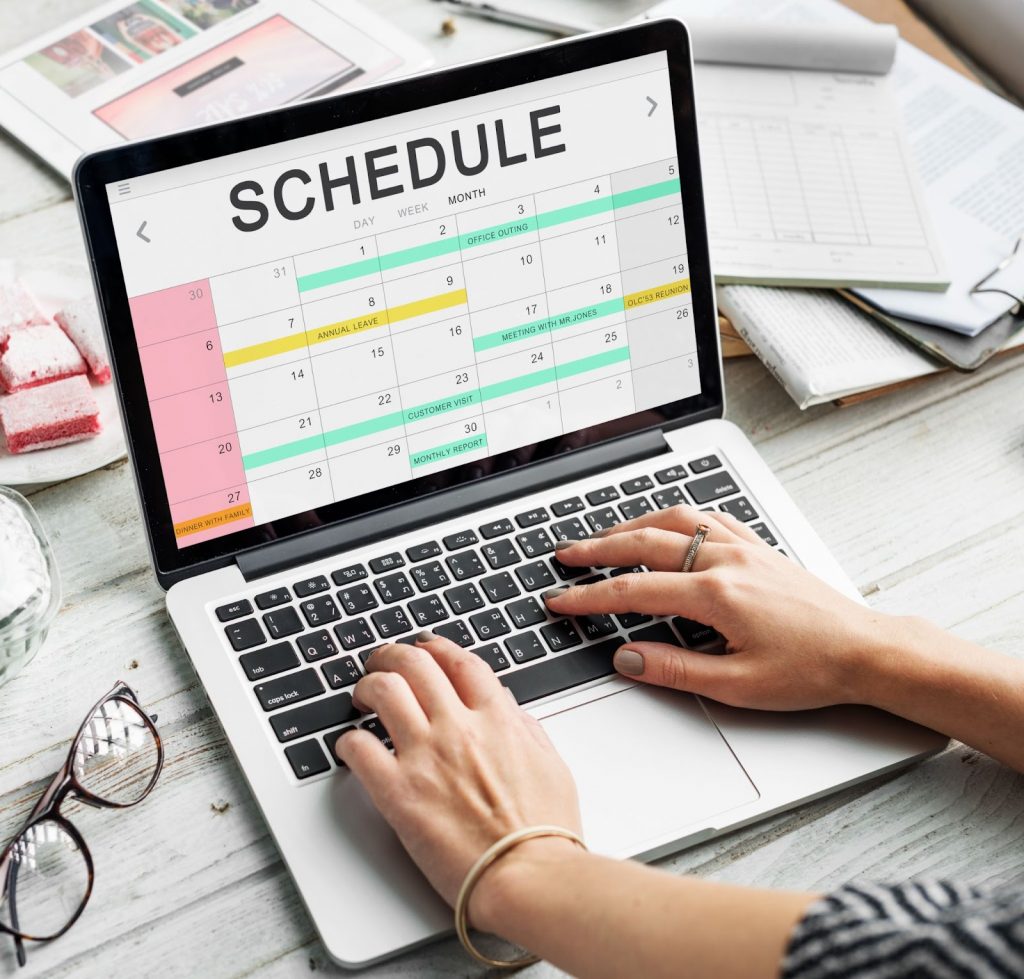 A lady creating a schedule on laptop