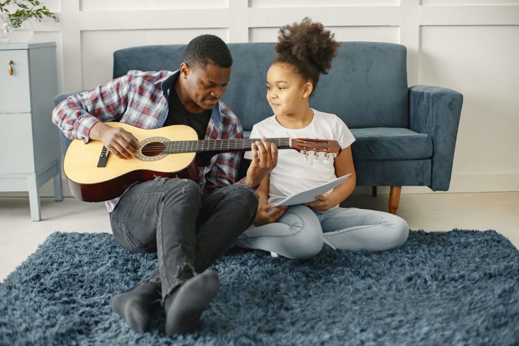 Father playing guitar with child