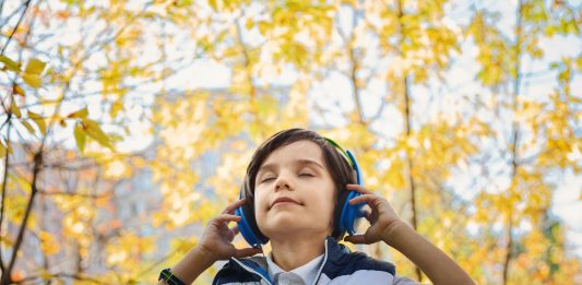 Little boy listening to music on headphones
