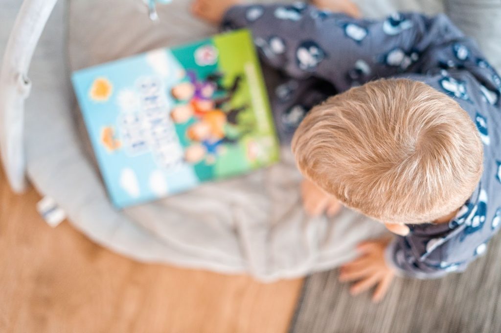 Boy reading a book on the floor