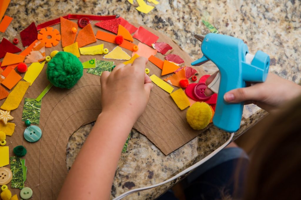 Kid making a rainbow collage