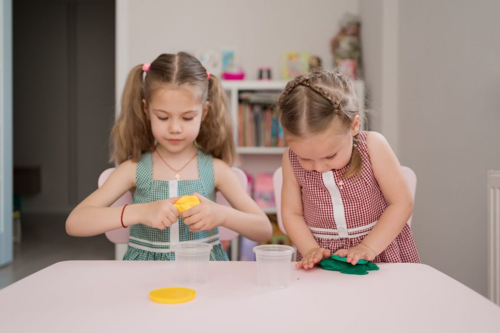 Two girls playing with playdough
